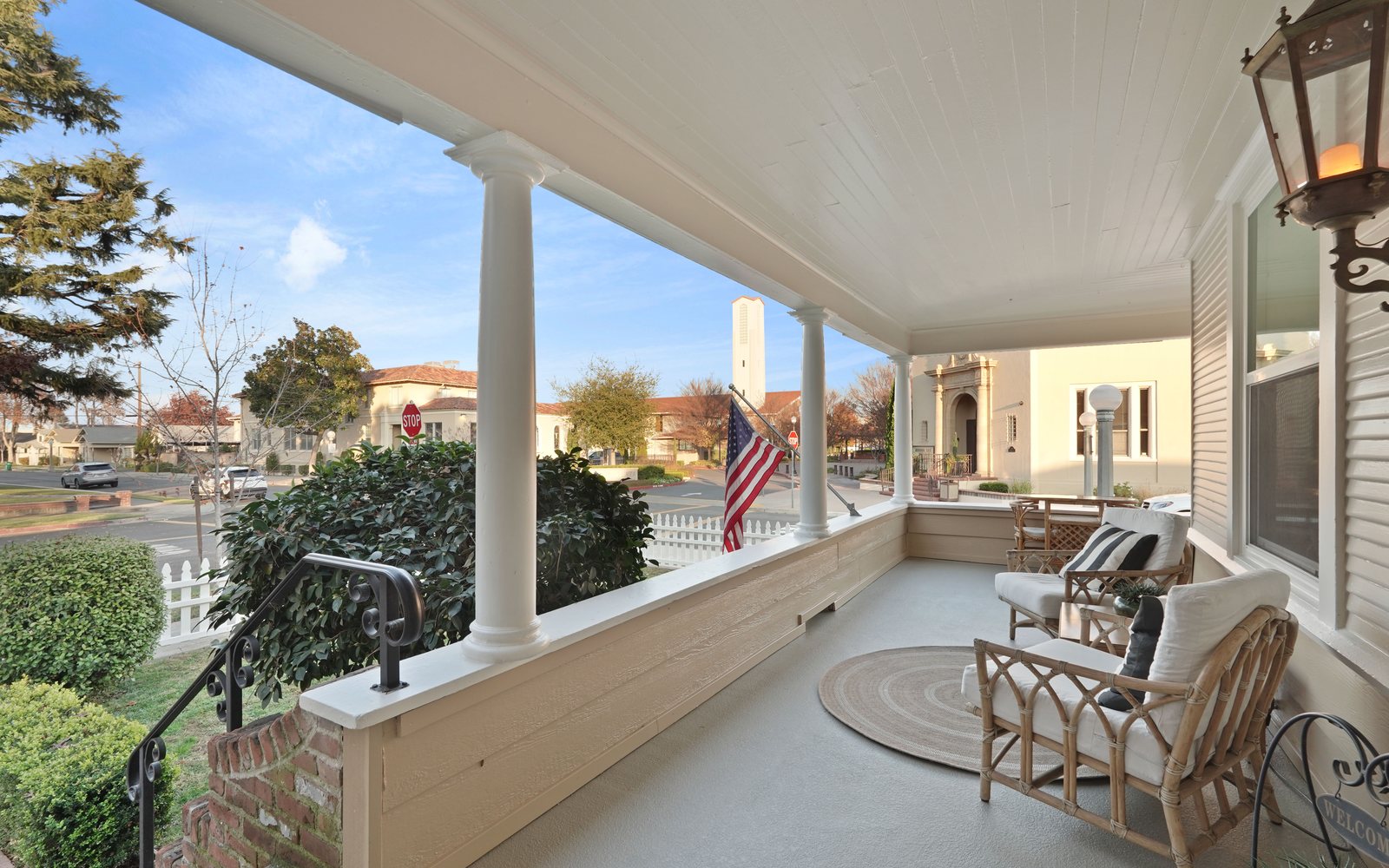 Sunlit wraparound porch with rattan seating — Lodi